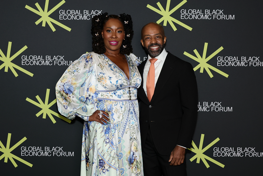 Dr. Topeka K. Sam with a guest in front of the forum backdrop.
