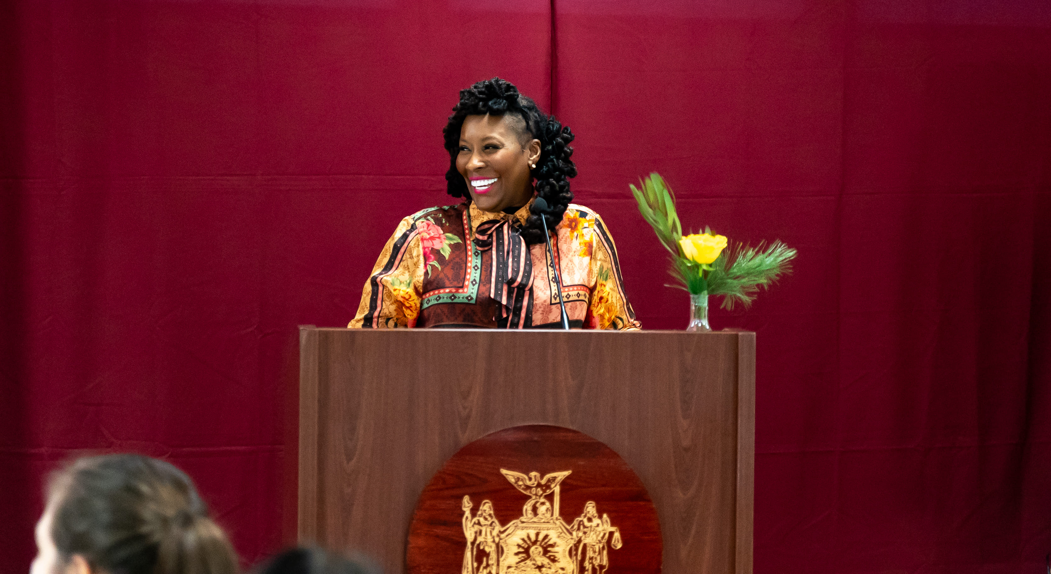 Dr. Topeka K. Sam speaking from a podium at Taconic Correctional Facility.