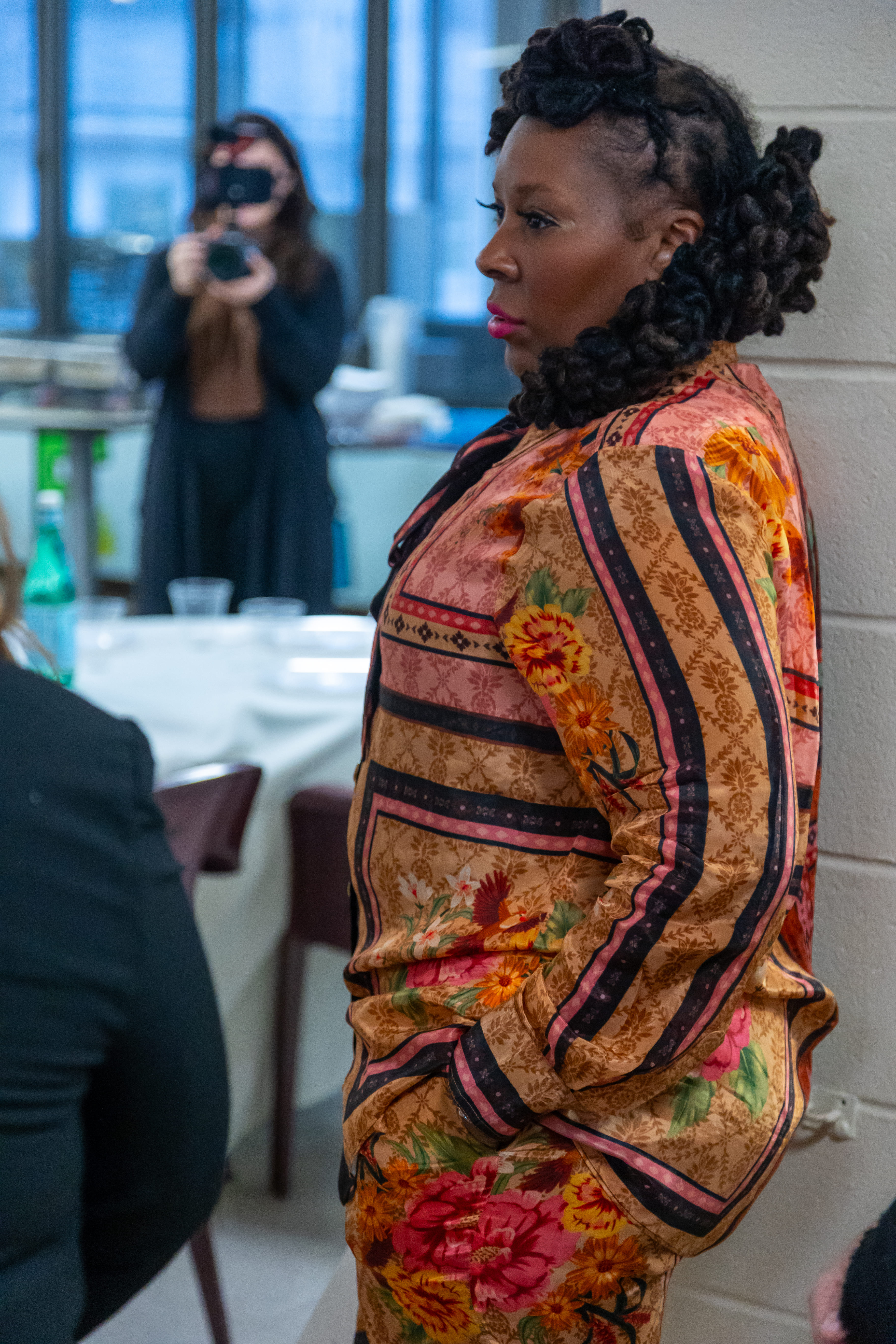 Dr. Topeka K. Sam standing in the dining hall as a photographer takes a picture.