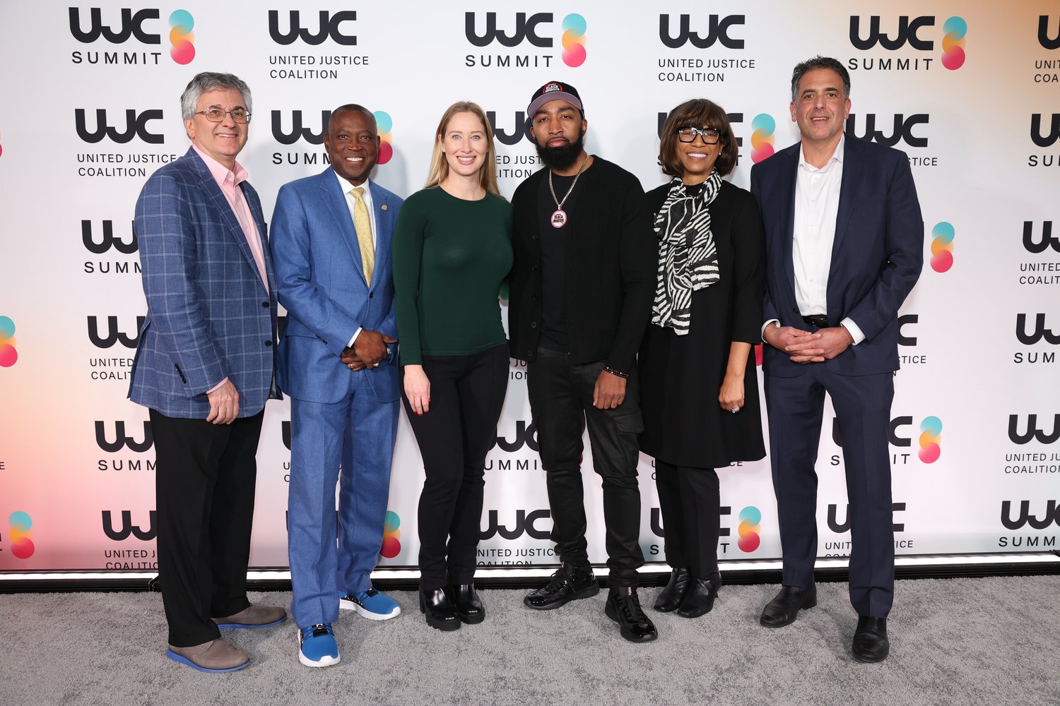 Eight speakers and organizers lined up at the UJC Summit backdrop.