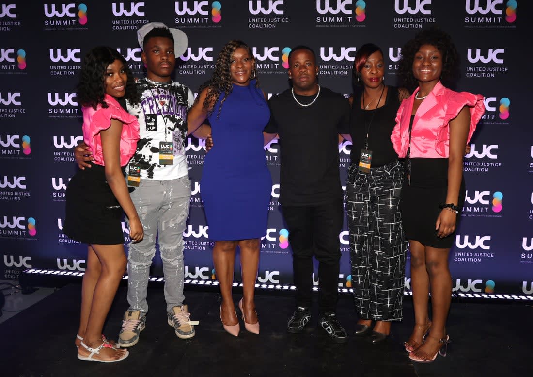 Six guests posing together at the UJC Summit backdrop.