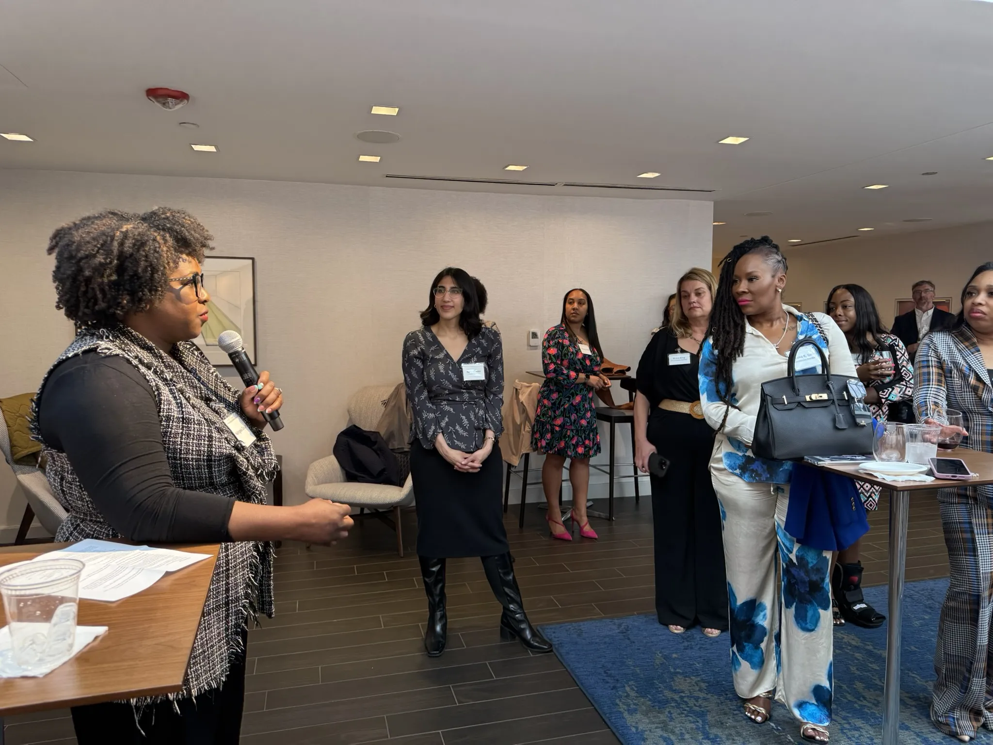 A speaker addresses attendees with a microphone during the commission conference reception.