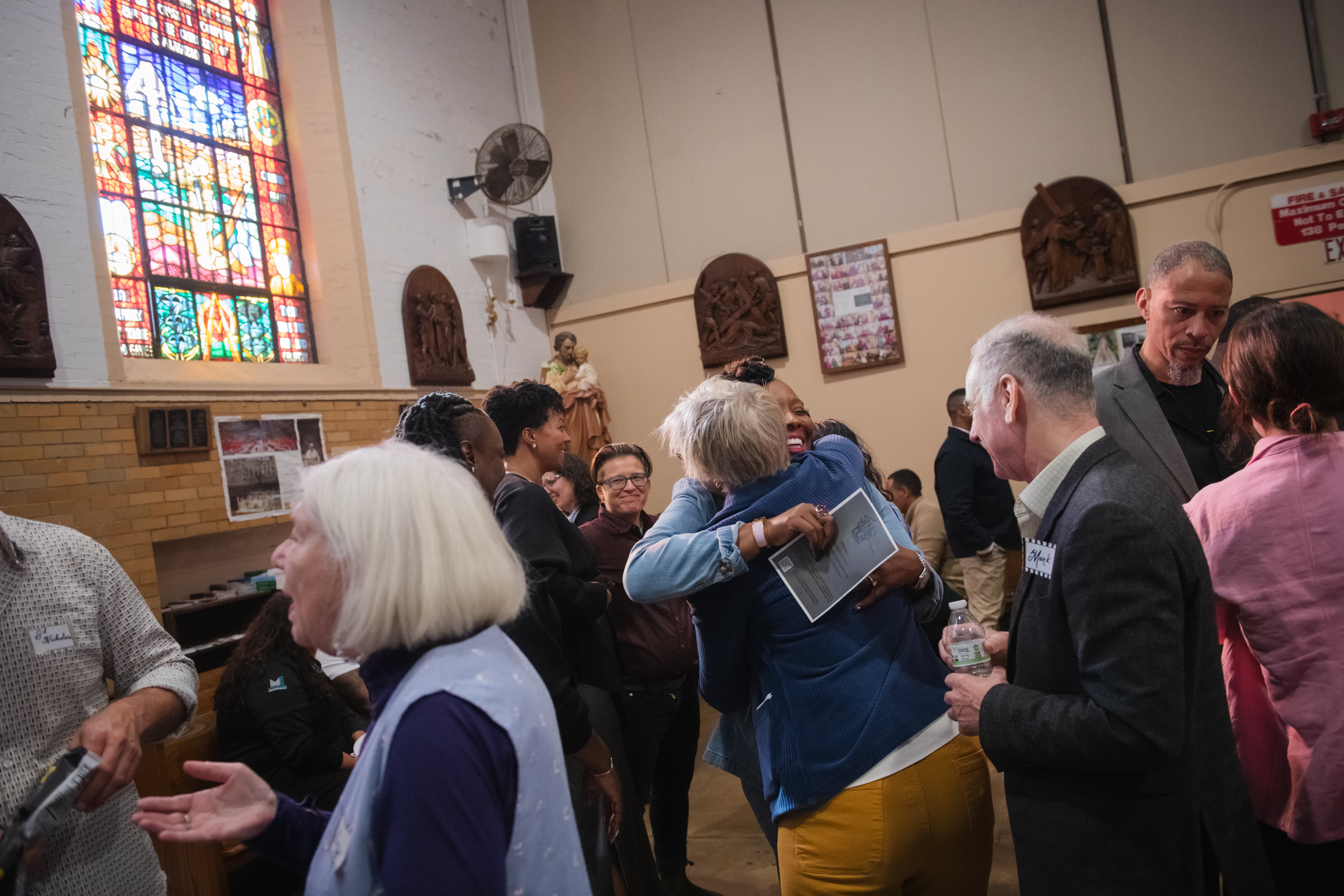 Festival attendees talking beneath the stained glass windows of the Sing Sing chapel.
