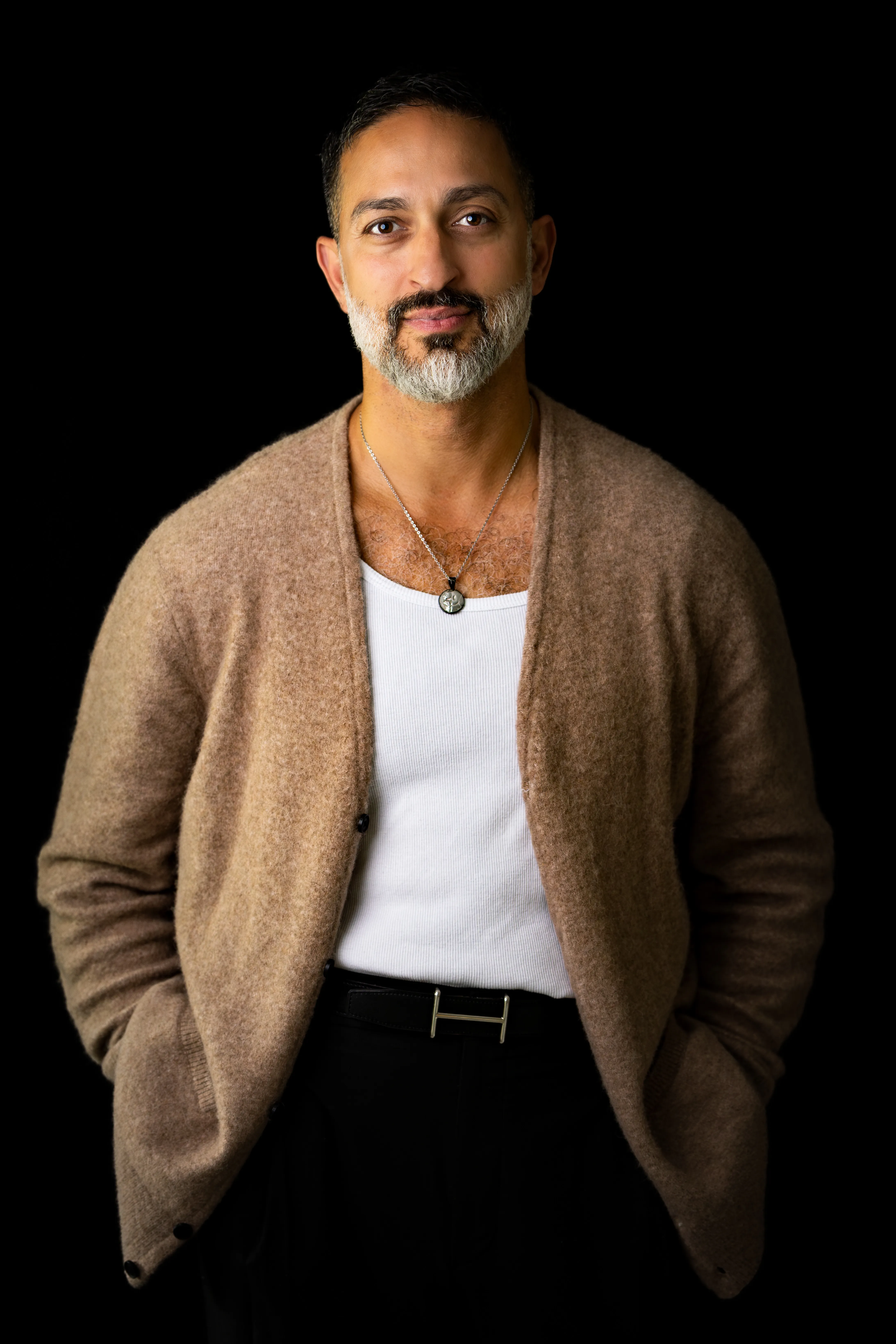 Borzou in a camel cardigan against a black background