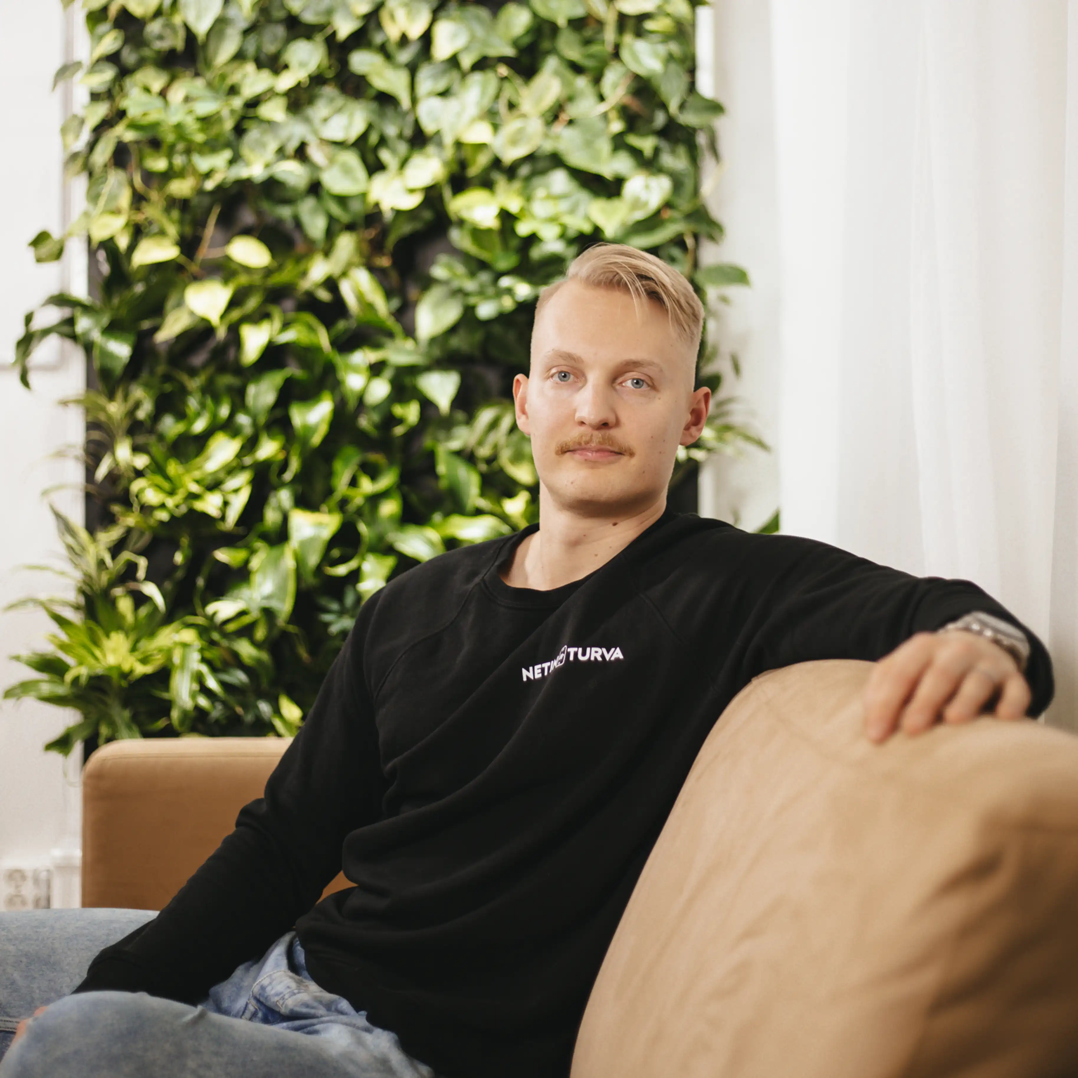 Netin Turvan perustaja istuu sohvalla