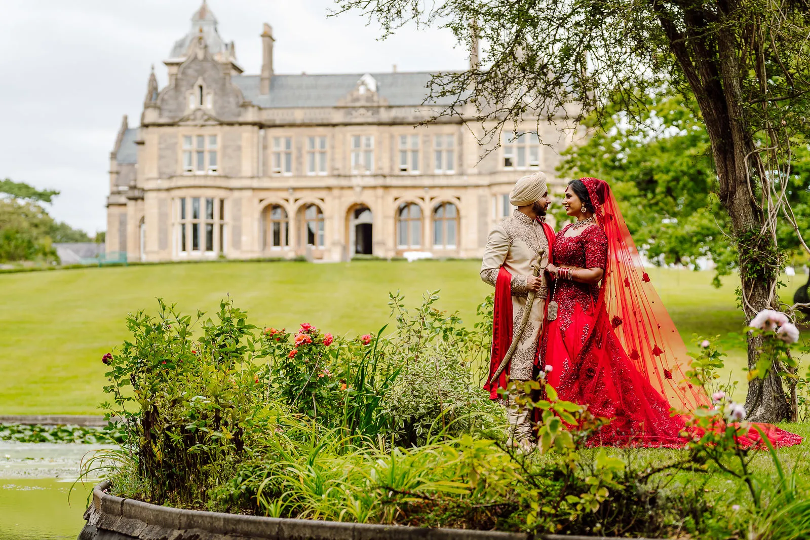 A bride and groom standing in front of a castle.
