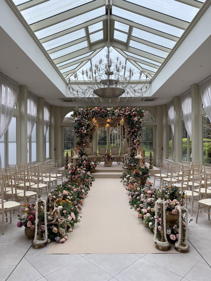 a wedding ceremony with chairs and flowers in the Orangery at Clevedon Hall