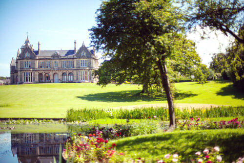 A long range photo of the gardens of Clevedon Hall with the mansion/country house in the background.