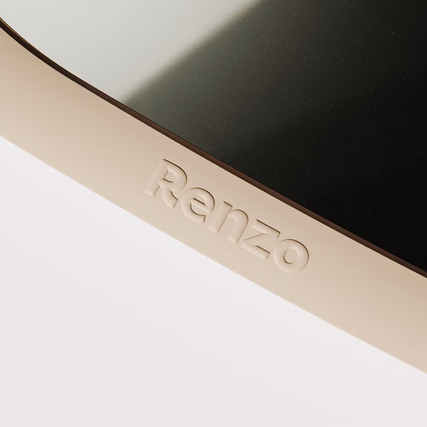 Close-up of a curved and soft embossed Renzo logo on the designed almond cream mirror frame