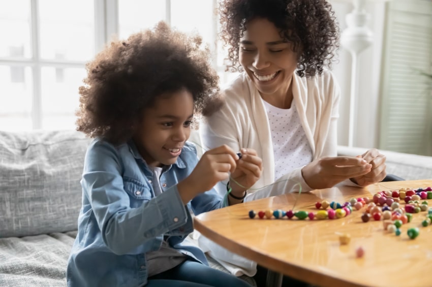 A mum and son creating an epilepsy bracelet