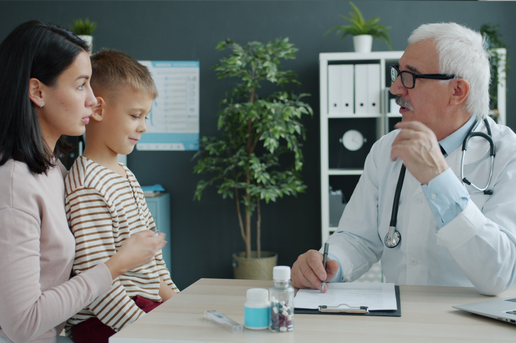 A doctor speaks with a mother and her young son about epilepsy brain surgery