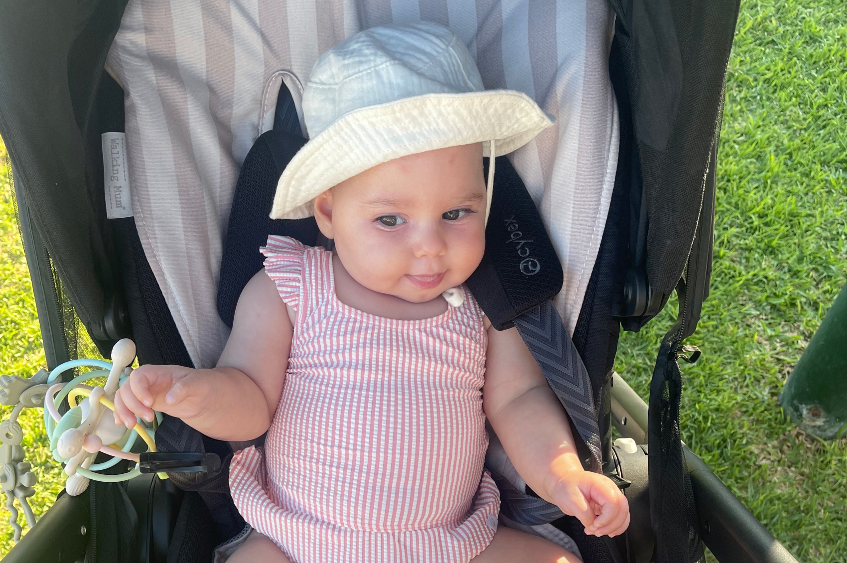 Baby Astrid smiling in a pram