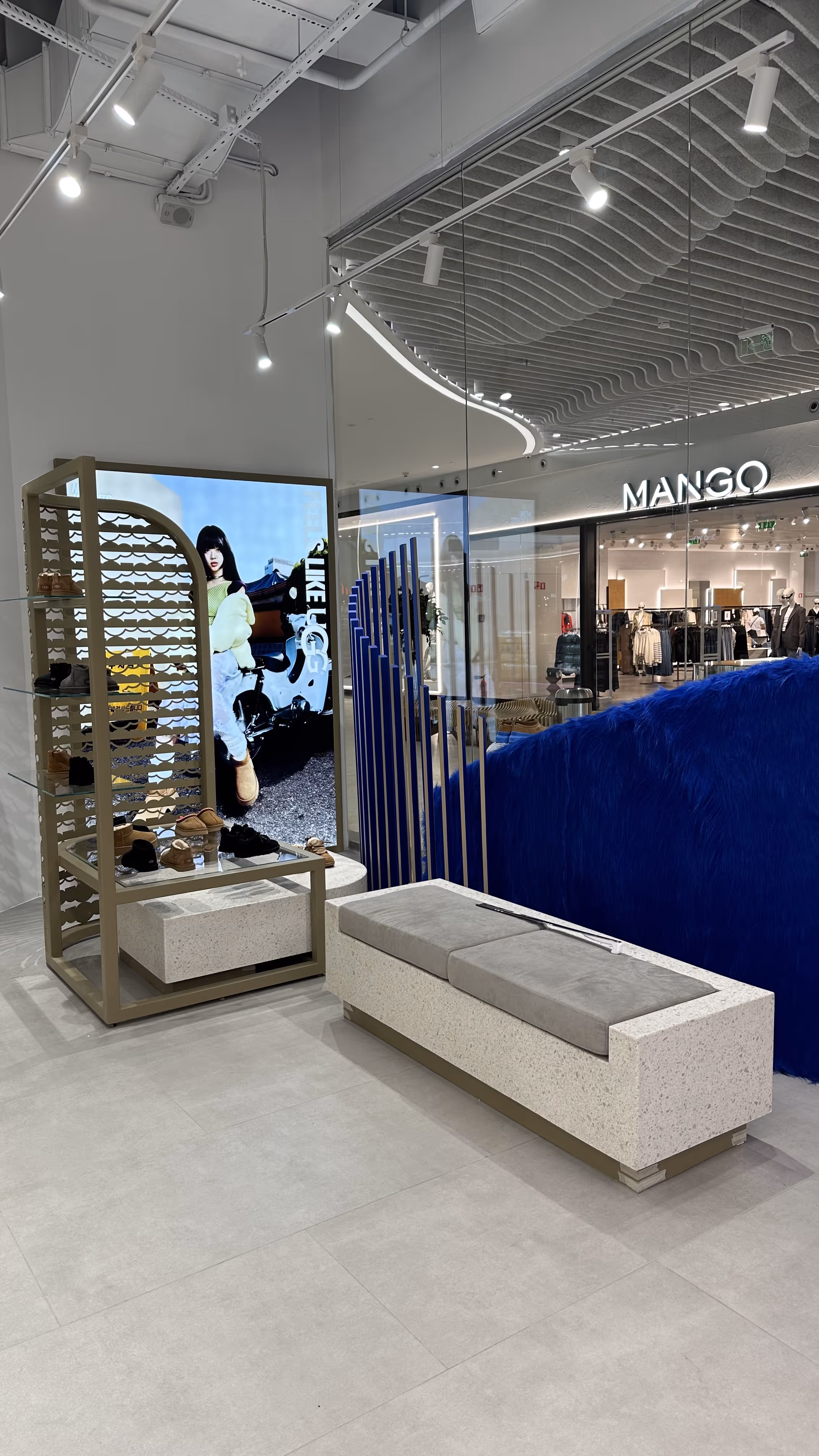 UGG boutique showcasing a variety of winter boots, slippers, and shoes in a modern, minimalist space with soft, warm lighting.