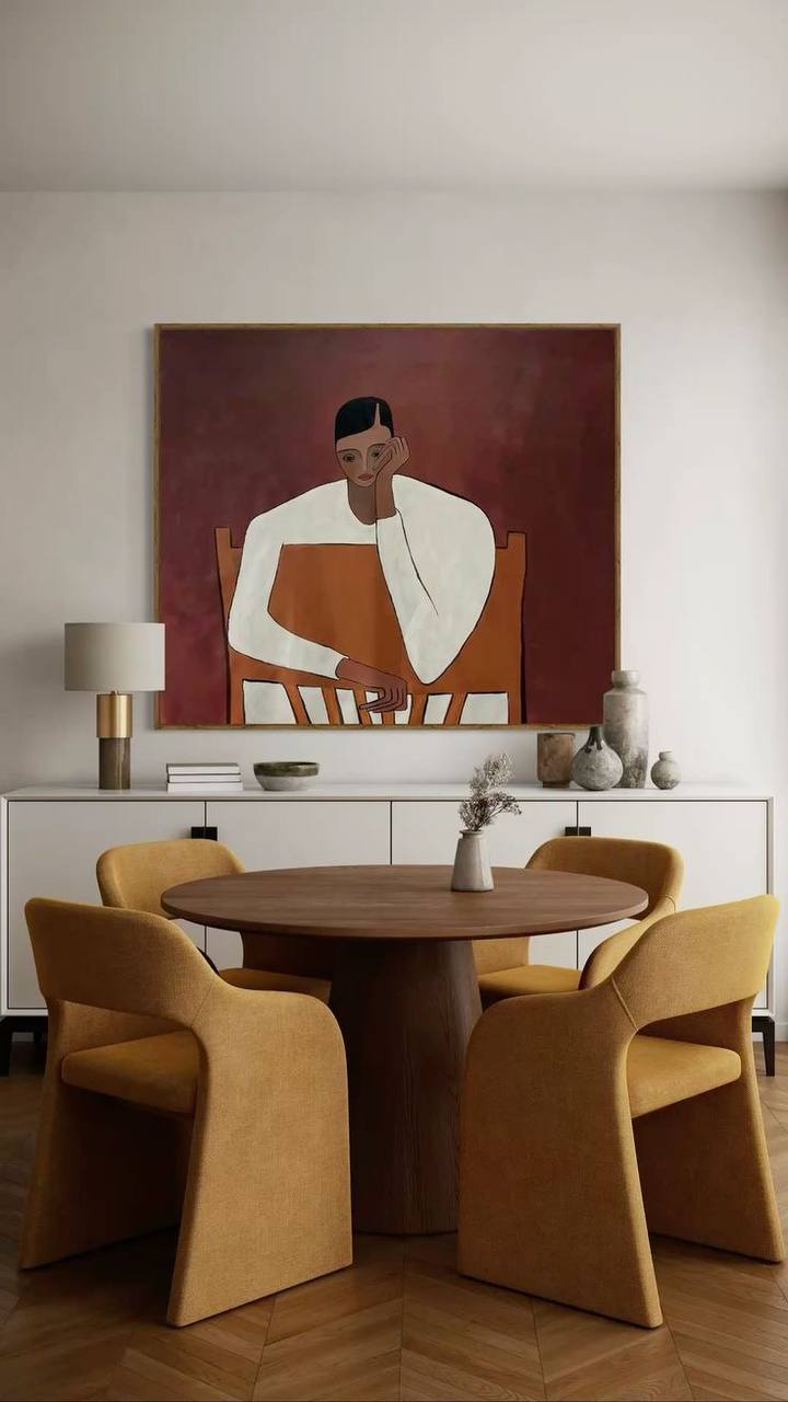 Modern dining area with round wooden table, mustard upholstered chairs and minimalist wall art, interior color trends 2026