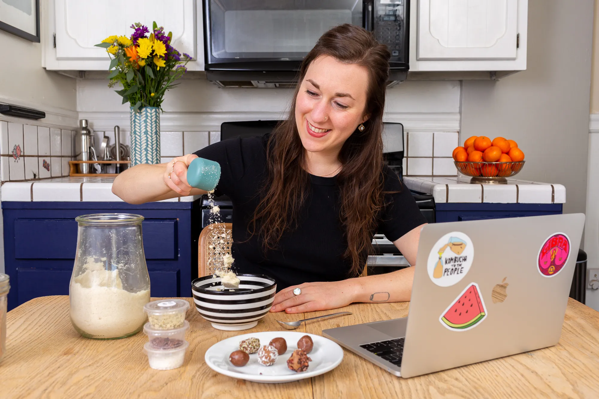 Person adding almond flour to a bowl while preparing superfood truffles during a virtual corporate wellness workshop