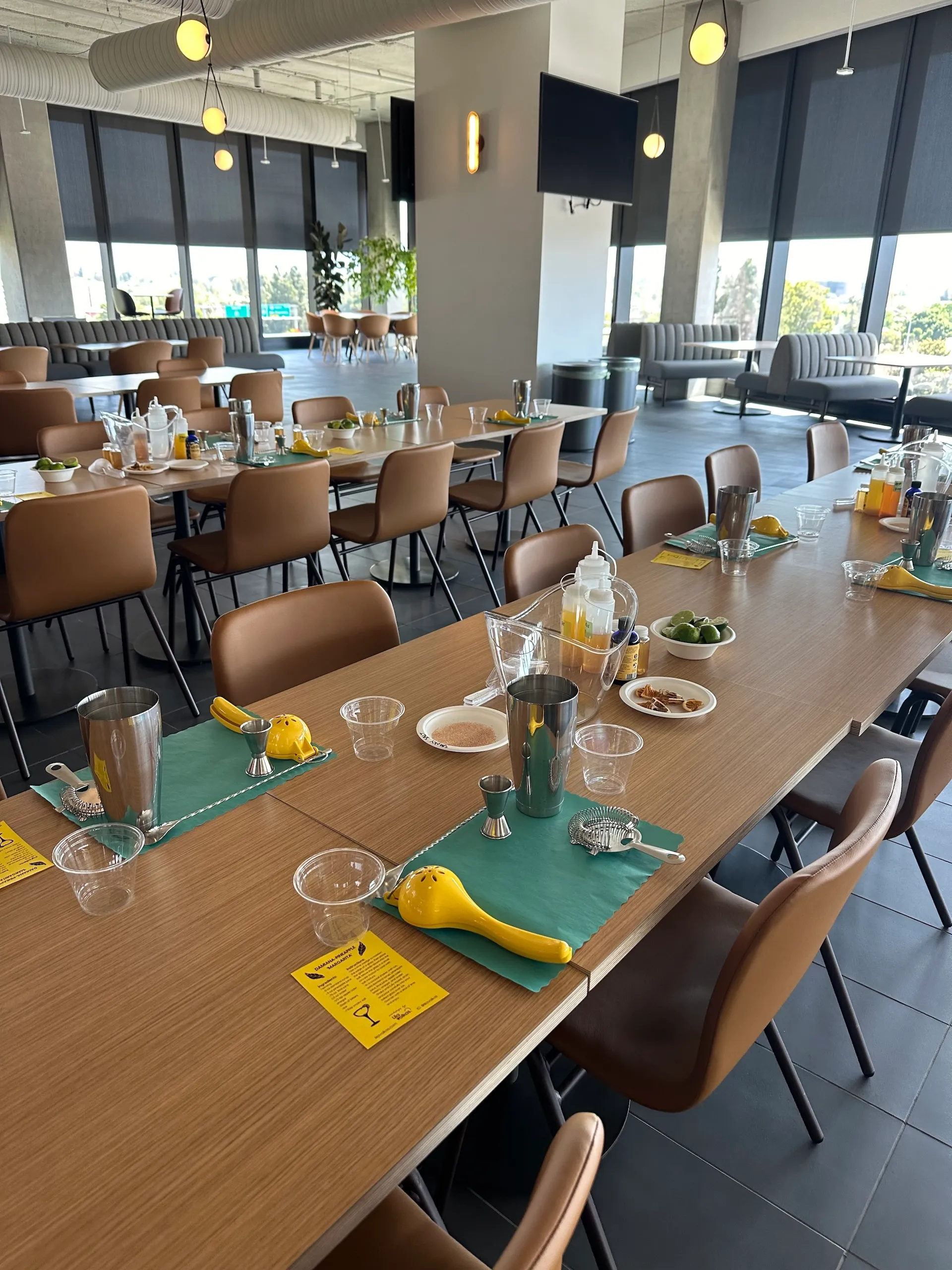 A room with tables with ingredients and tools on, ready for a mixology class.