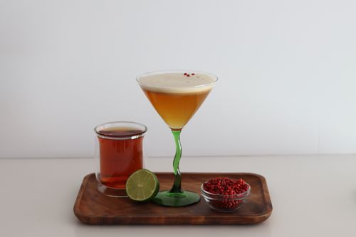 Matcha strawberry mocktail garnished with lime on checkered background made during corporate mocktail mixology class