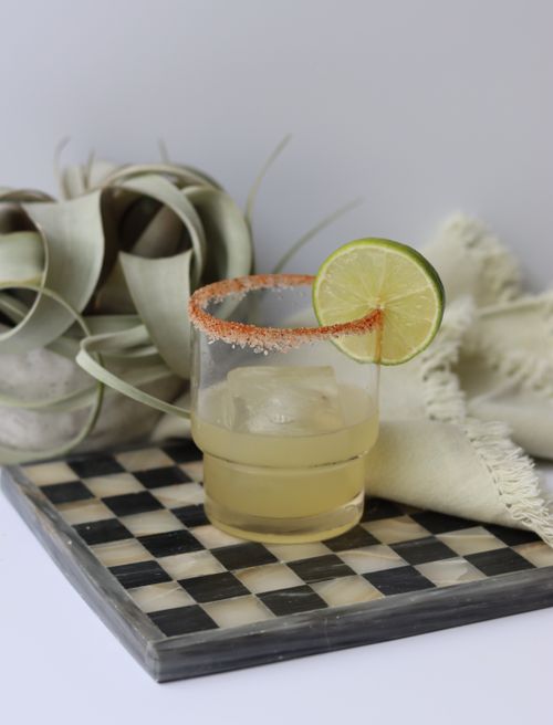 Salt-rimmed glass with lime garnish and a green herbal mocktail made during a non-alcoholic mocktail workshop