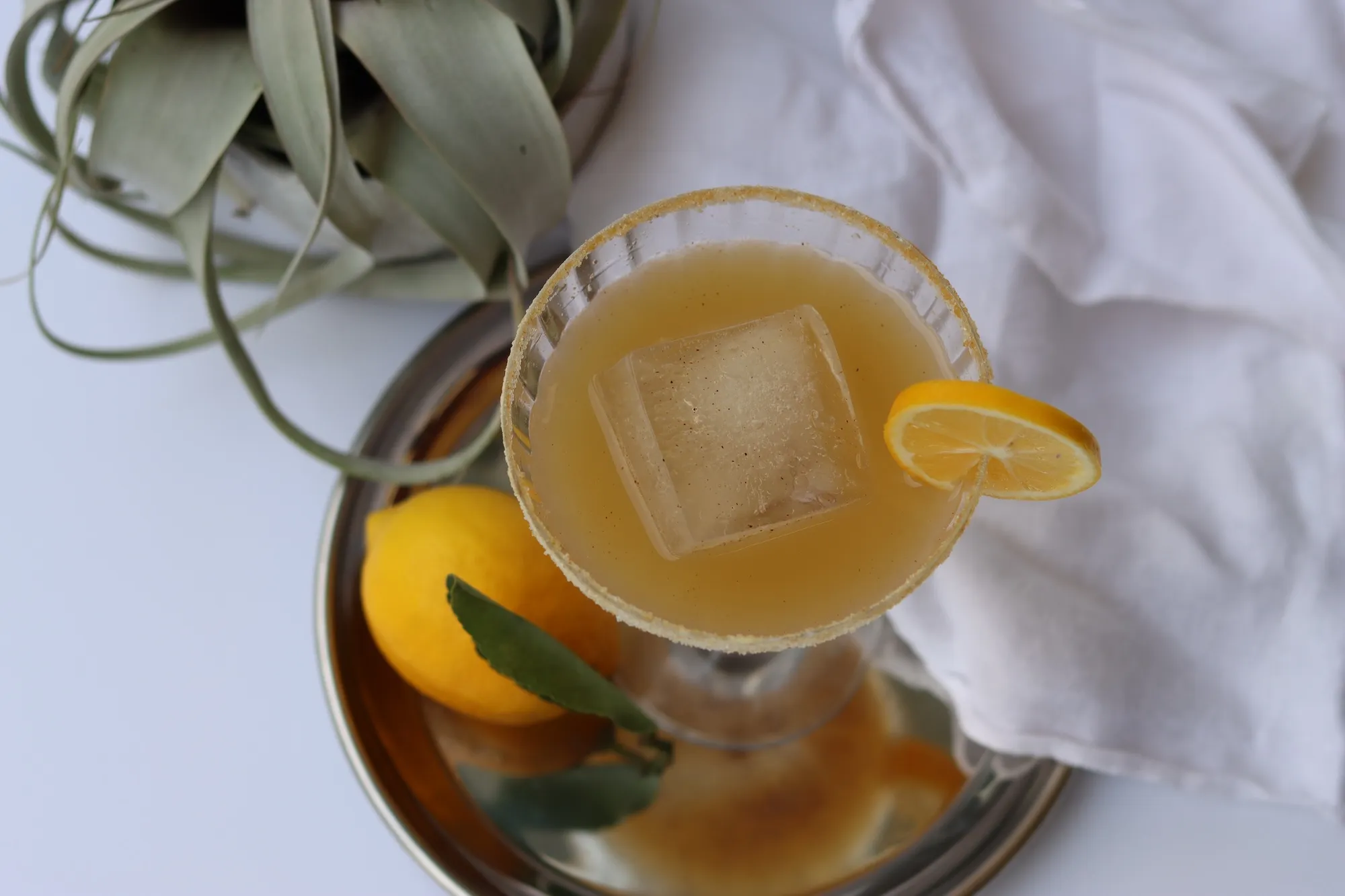 Ginger lemon mocktail in coup glass made during virtual mocktail mixology workshop.