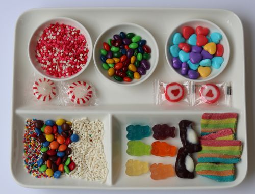 Valentine's day themed gingerbread house love shack decorated with pink candies made during a festive team building event
