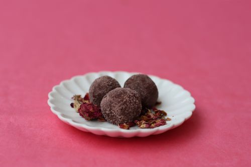 Pink mocktail with roses in the background made for Valentine's Day themed corporate mixology event