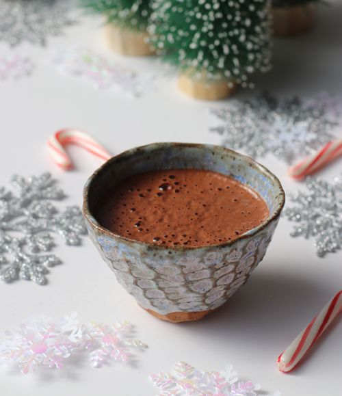 Woman chopping chocolate during a corporate elixir happy hour, blending wellness with fun in a team-building experience.