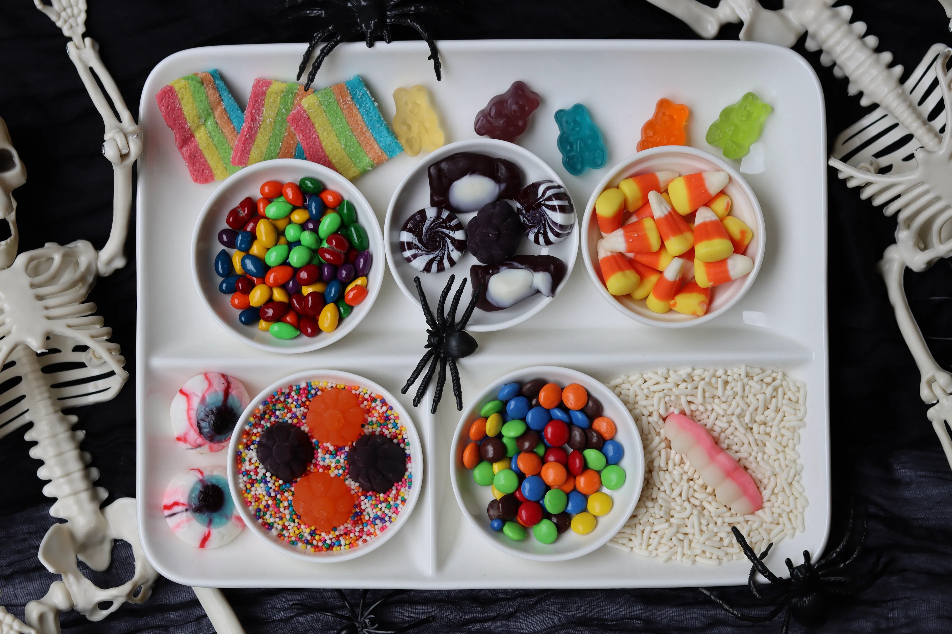 Halloween-themed gingerbread house with spooky decorations like candy corn and eerie candy eyes, made for festive team-building activities