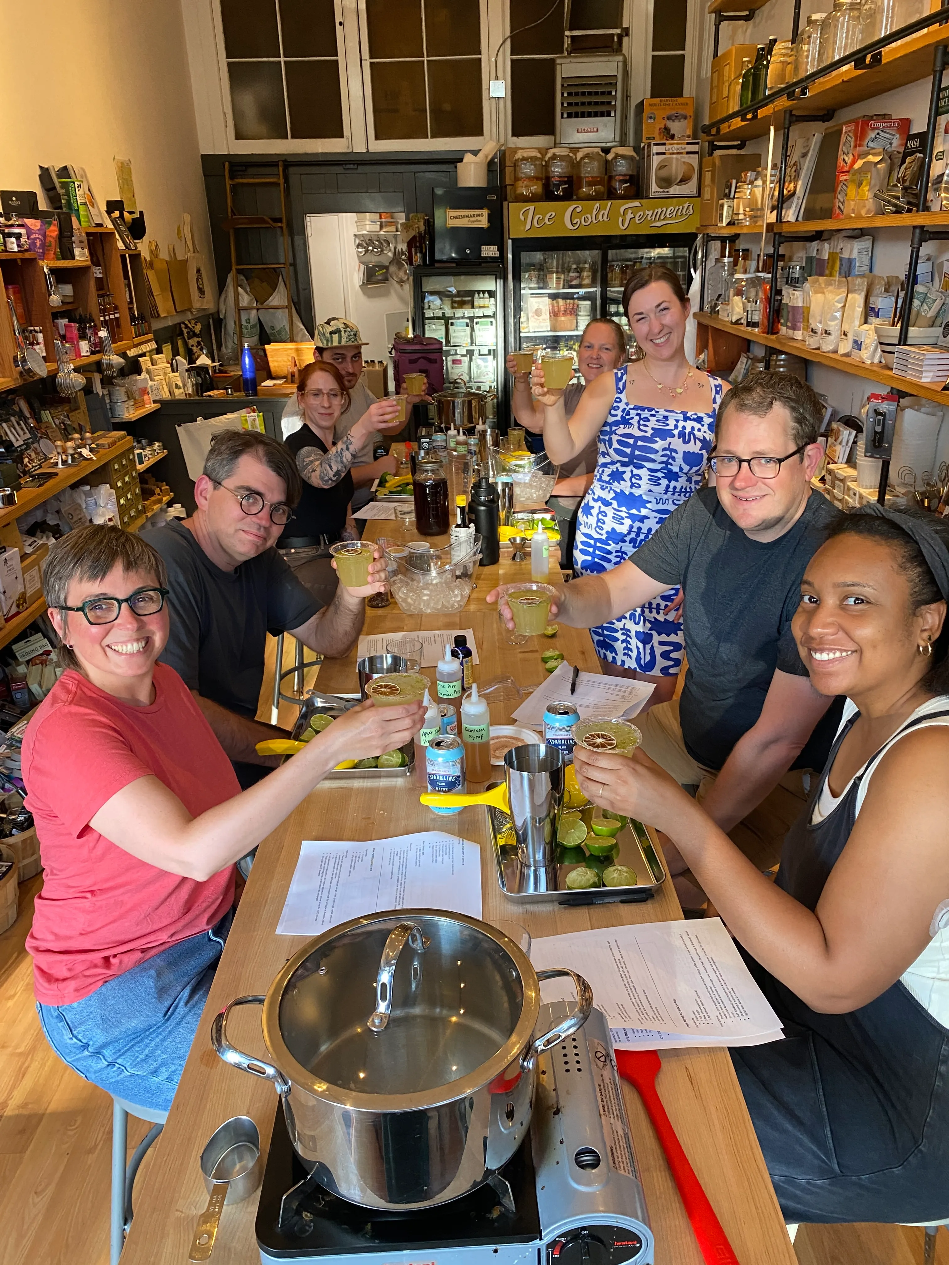 Group of people smiling and holding up mocktails during mocktail mixology event in Oakland, California.