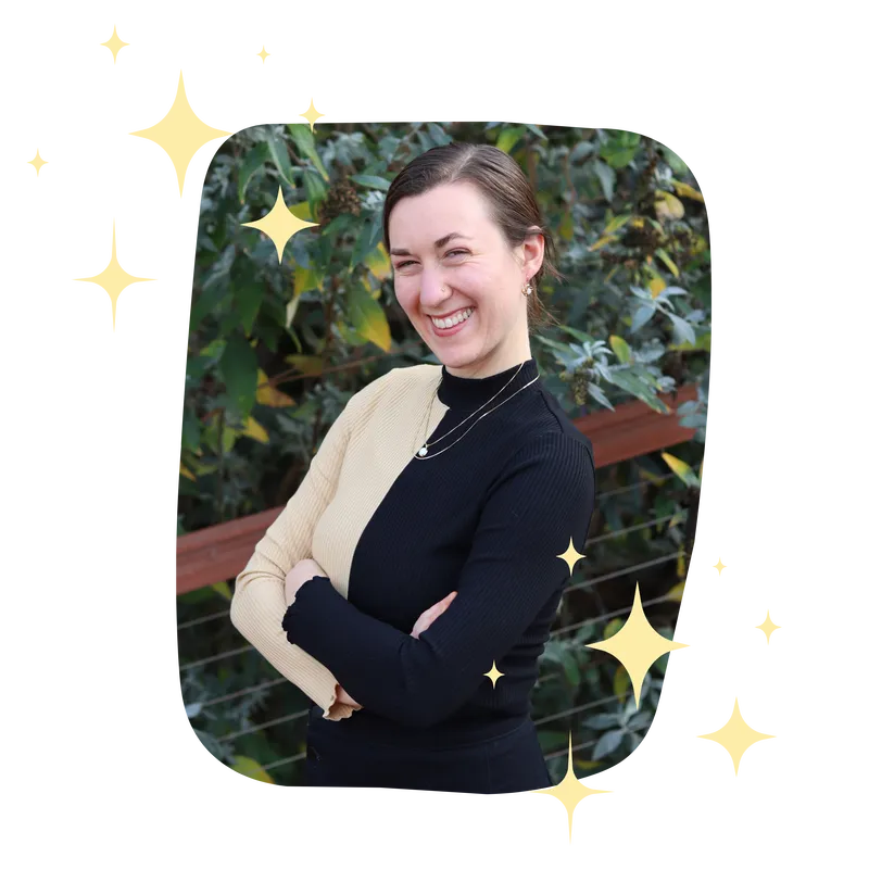 Woman smiling confidently with her arms crossed, animated sparkles surround the image