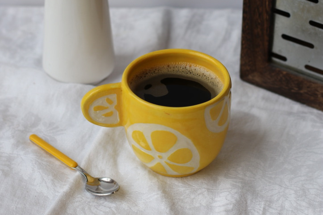 Herbal coffee in yellow mug on white background during corporate team building