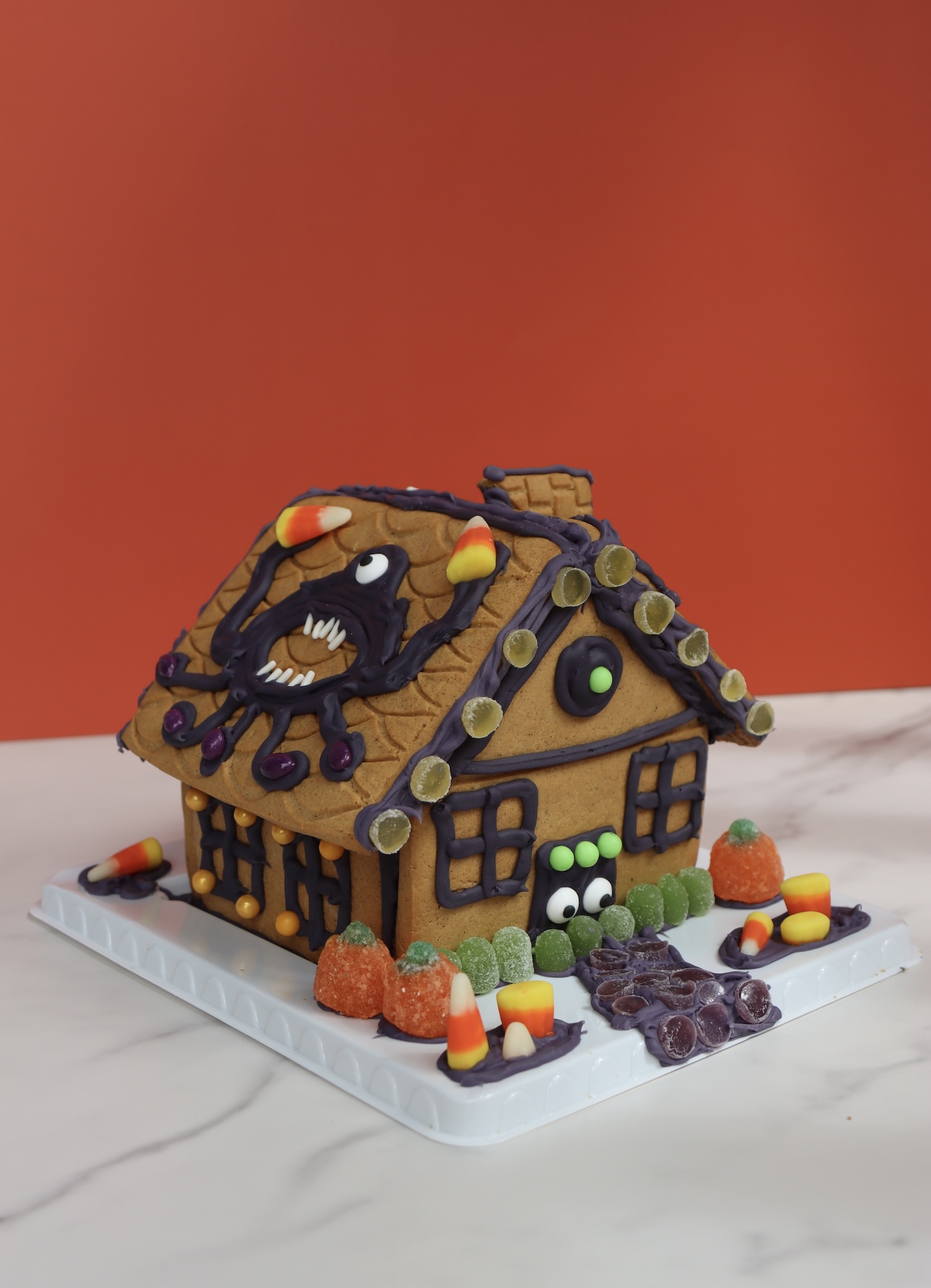 Halloween-themed gingerbread house cookie with candy decorations made for festive team-building activities