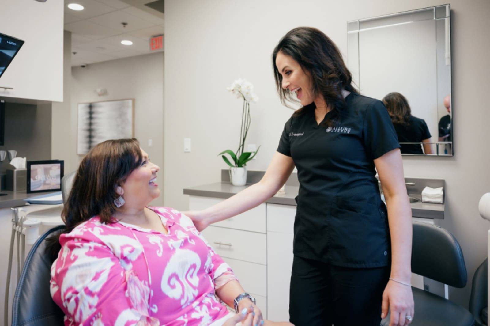 Allure Dental team member consulting with patient in treatment room