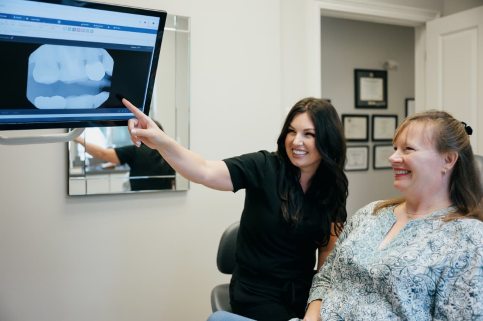 Dentist and patient reviewing digital smile design on computer screen