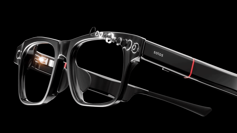 Animated close-up of Solos smart glasses, showing a camera on the left lens side emitting a bright light, with circular elements radiating outward in a stylized explosion effect.