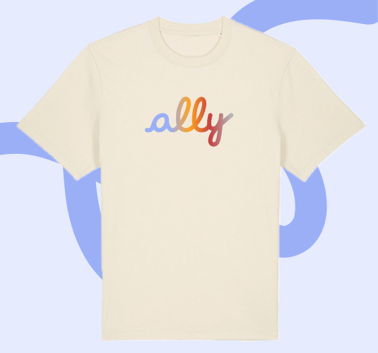 Cream-colored T-shirt with the word “ally” printed in lowercase script across the chest, in gradient shades of light blue, orange, and red, displayed against a pale blue background with a darker blue abstract swirl.