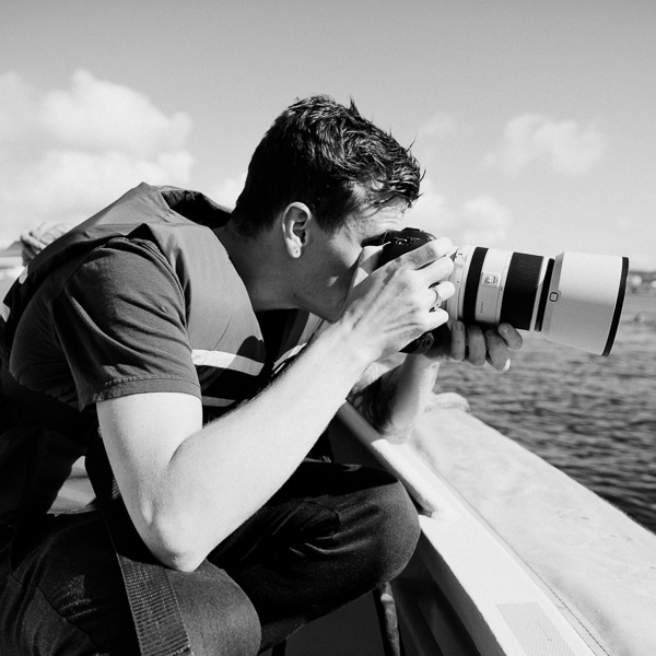 Fotograf i redningsvest tar bilder fra båt mot åpent hav – maritim foto Stavanger.