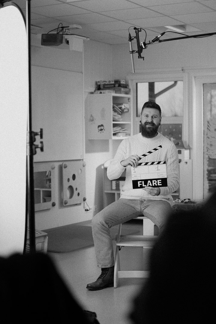 Produksjonsdag i klasserom – regissør med klapp-tavle merket «Flare» foran boom-mikrofon (videoproduksjon Stavanger).