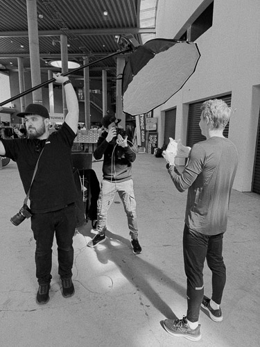 Team fra Flare i Stavanger som samarbeider under en fotoshoot med lysrigg og kamera. Bak kulissene-foto som viser kreativt arbeid i praksis.