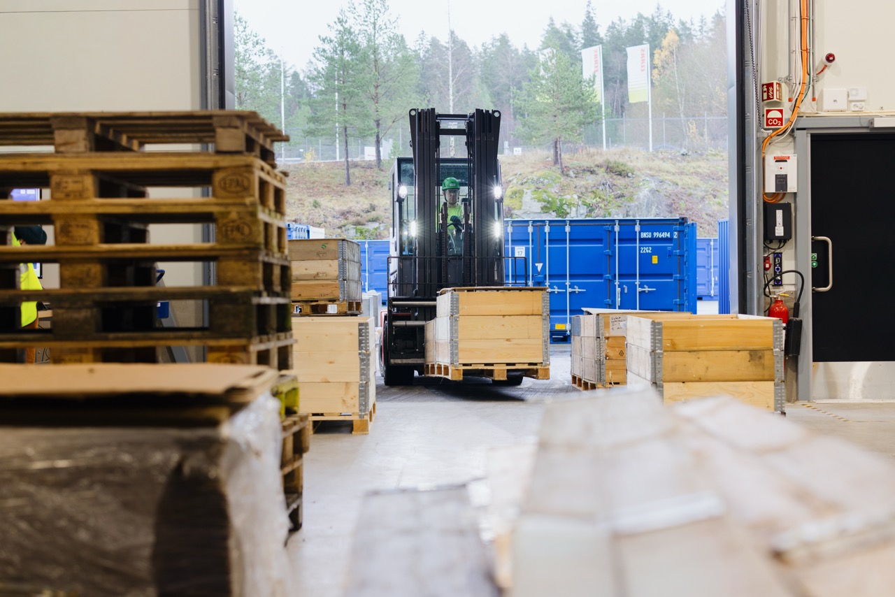 bedriftsfotograf dokumenterer logistikk og lagerdrift med gaffeltruck i aktivt arbeidsmiljø