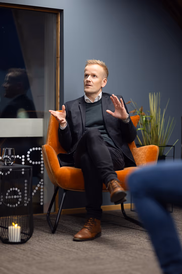 Leder i oransje stol gestikulerer under intervju – bedriftsfoto Rogaland