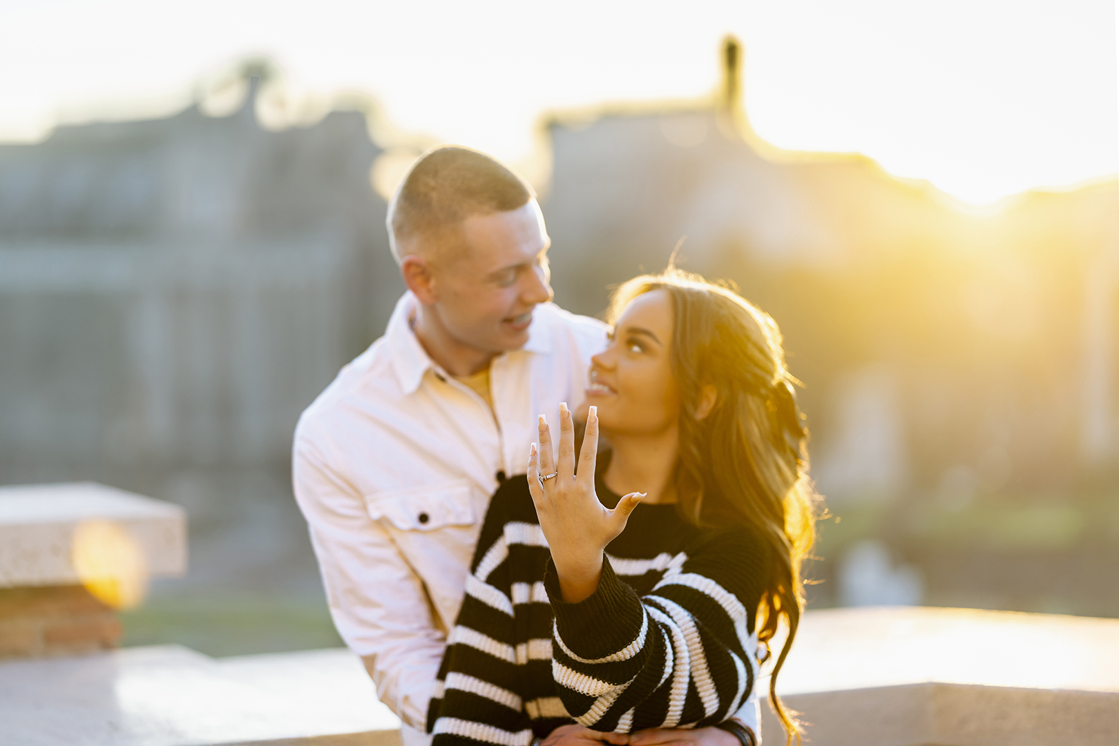 Just-engaged ring reveal at Capitoline Hill with the Roman Forum in soft sunset bokeh.