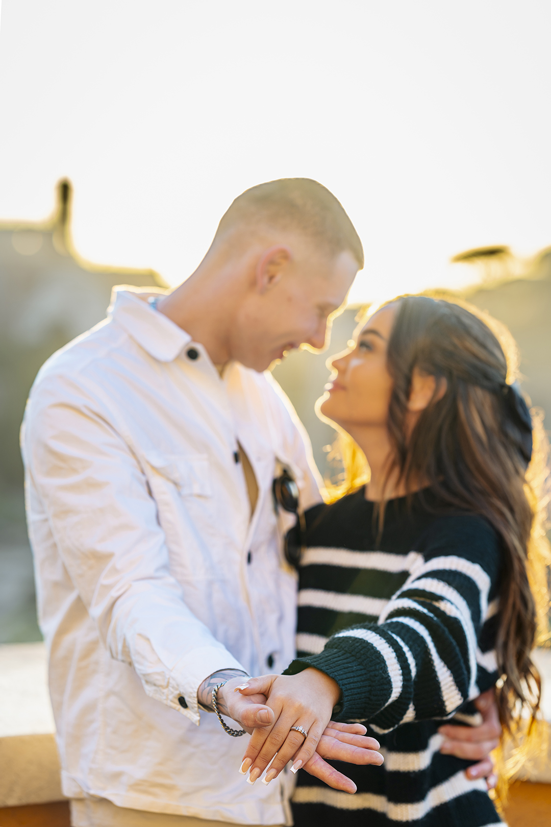 Close-up of joined hands with engagement ring during a Capitoline Hill proposal at sunset.