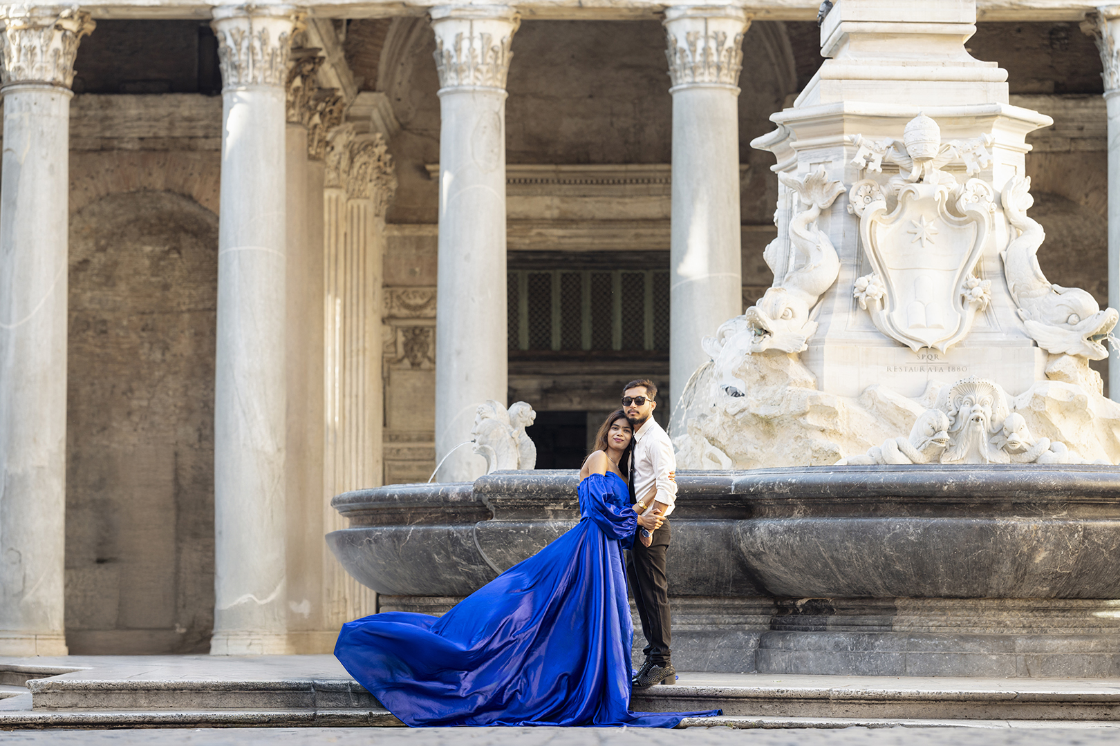 Flying dress at the Pantheon fountain, Rome—royal blue gown flowing beside the portico columns