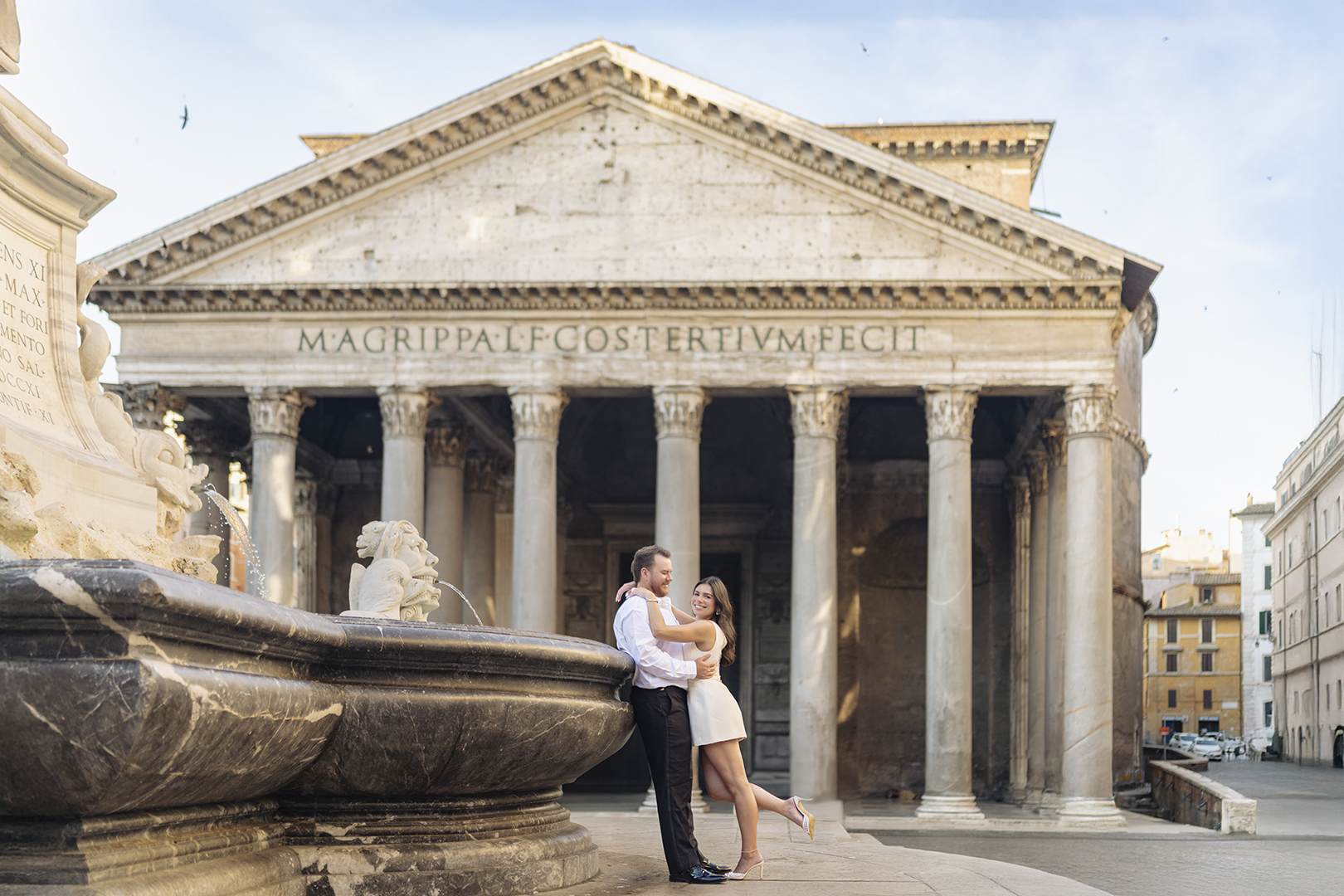 Romantic couple posing in front of the Pantheon Rome with fountain details, photographed by Eidos Photography Rome photographer Jeff in the morning light.