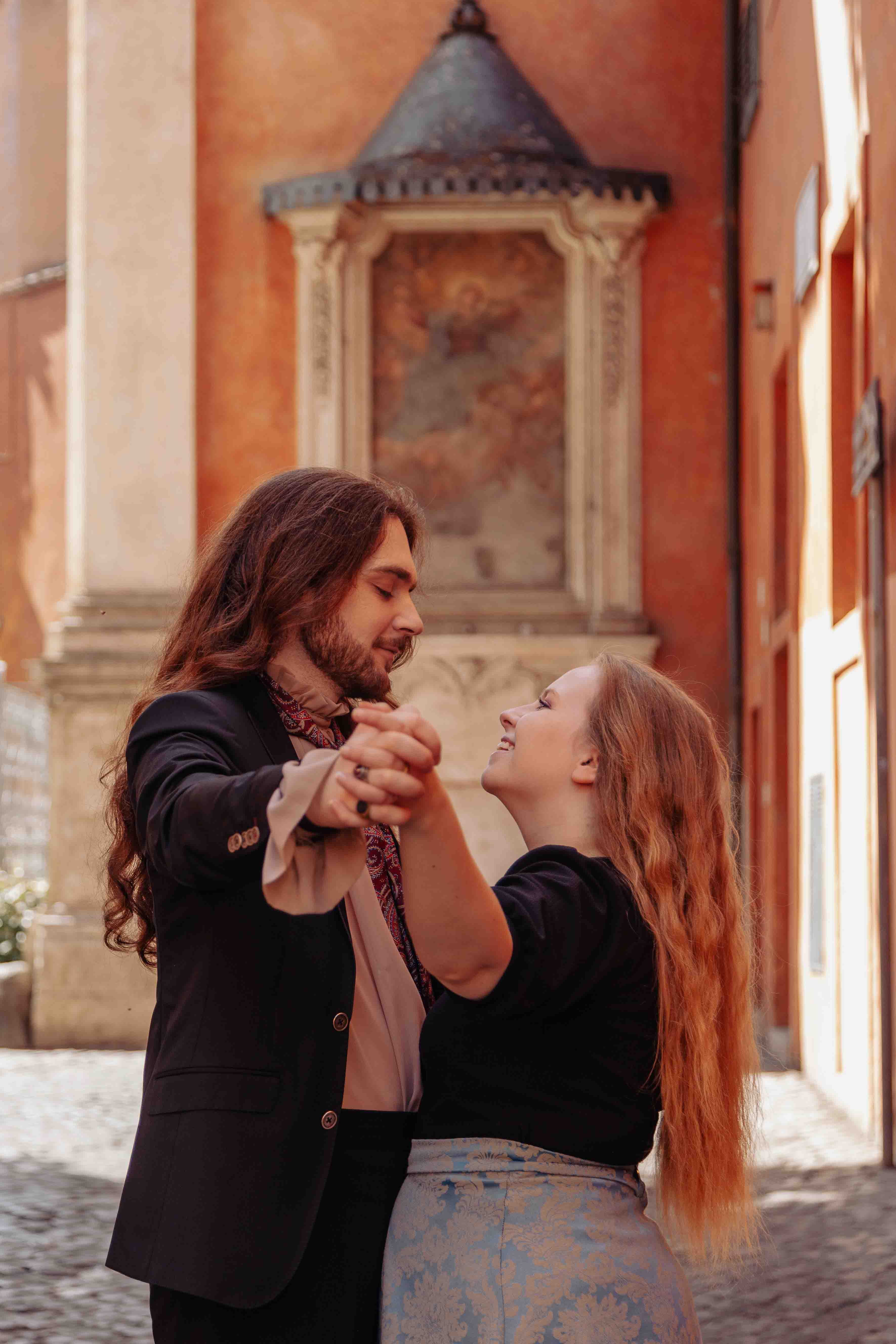 Romantic couple dancing closely during a photoshoot in Trastevere, Rome, captured by Eidos Photography with warm natural light and soft tones.