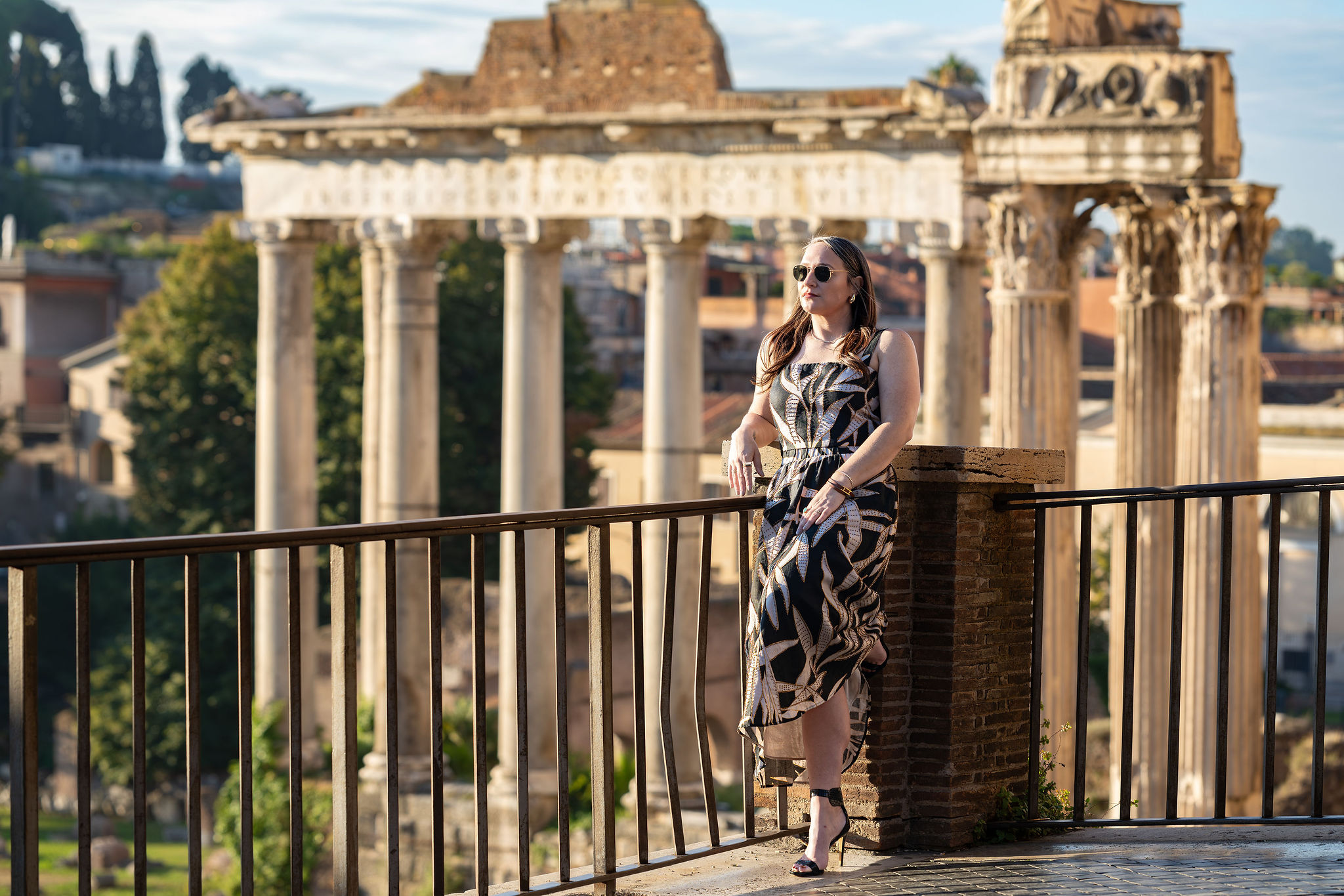 Woman standing on a terrace above the Roman Forum at golden hour during an early morning photoshoot in Rome with Eidos Photography, Rome photographer.