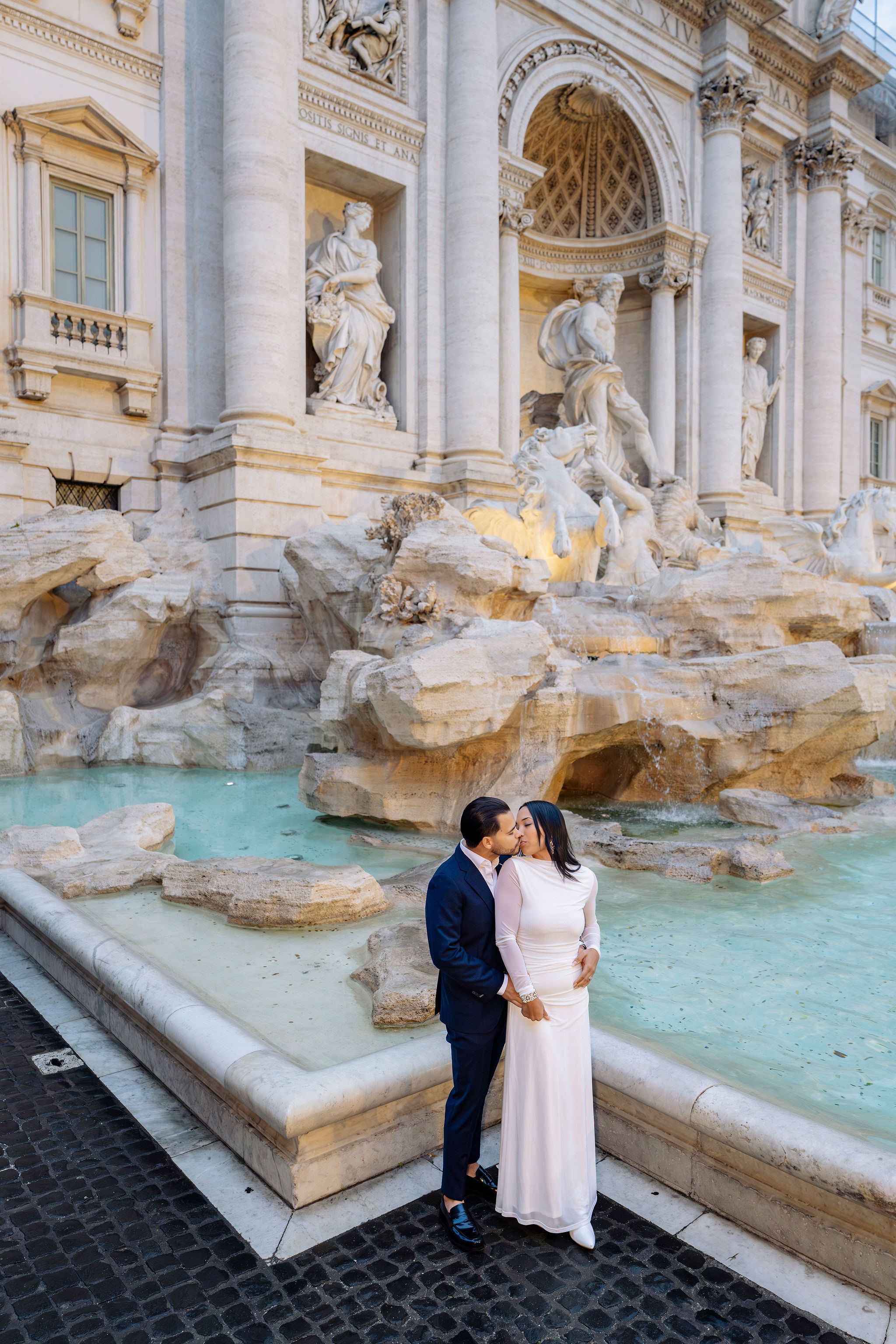 Couple kissing during a Grand Tour Rome photoshoot at Trevi Fountain, captured by Eidos Photography, Rome photographer.