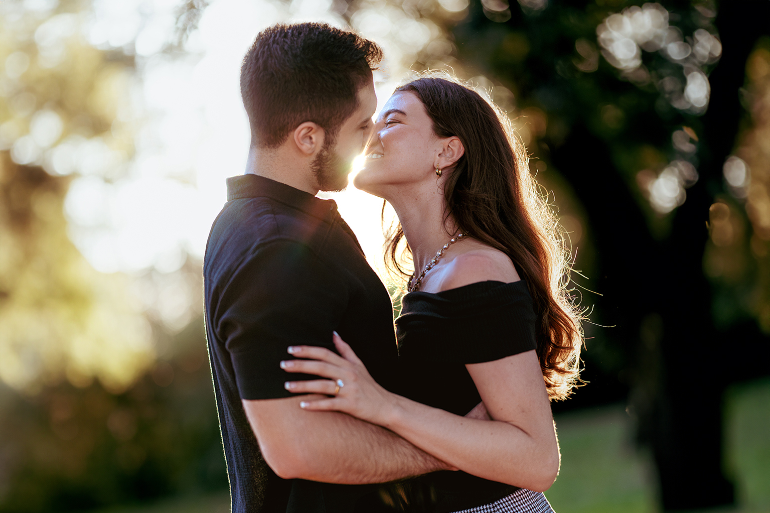 Couple kissing at golden hour in Villa Doria Pamphili, Rome, engagement ring visible during a romantic couple photoshoot by Eidos Photography, Rome photographer.