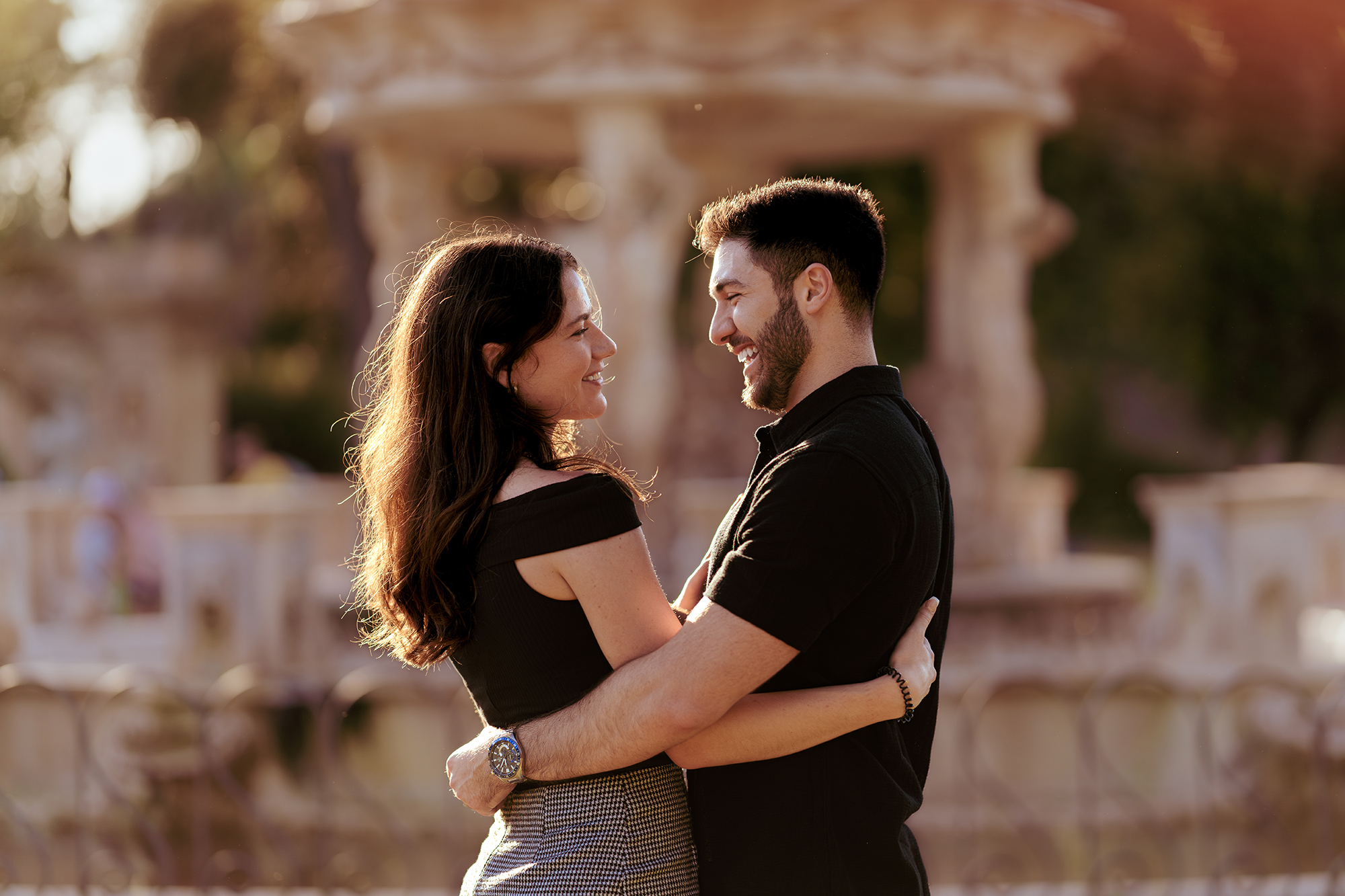 Couple hugging and smiling at golden hour in Villa Doria Pamphili, Rome, romantic couple photoshoot with soft bokeh background by Eidos Photography, Rome photographer.
