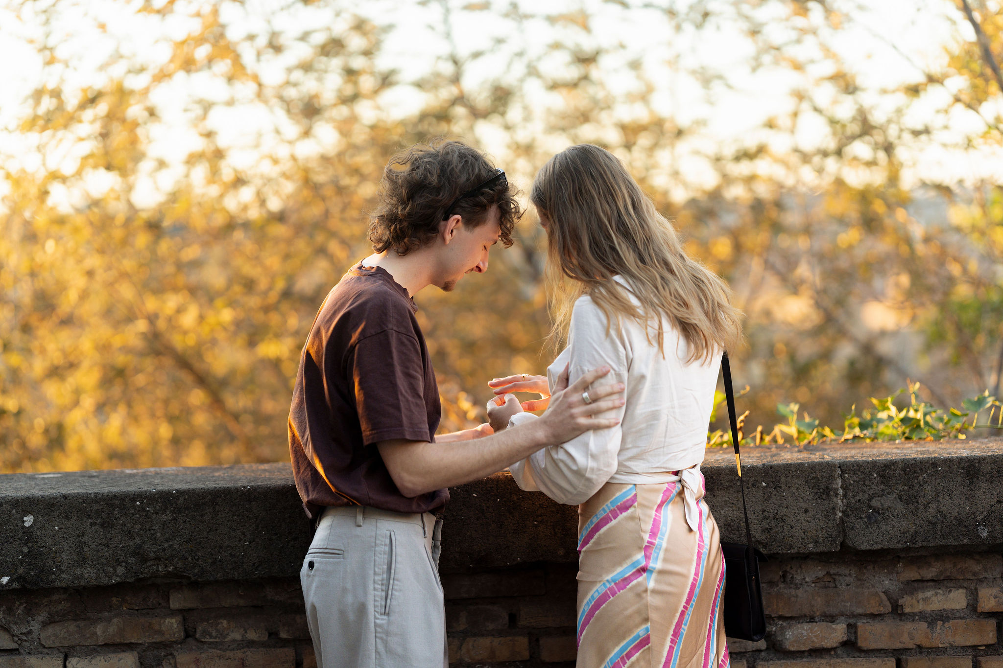 Couple sharing an intimate sunset moment on Aventine Hill in Rome during a secret proposal photoshoot, captured by Eidos Photography Rome photographer